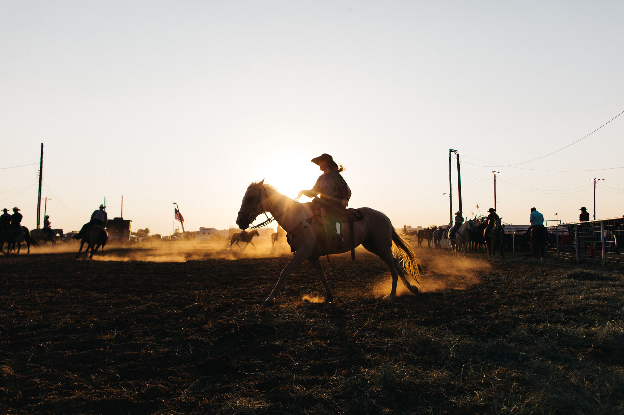Rider loping through the dust with the sun behind him