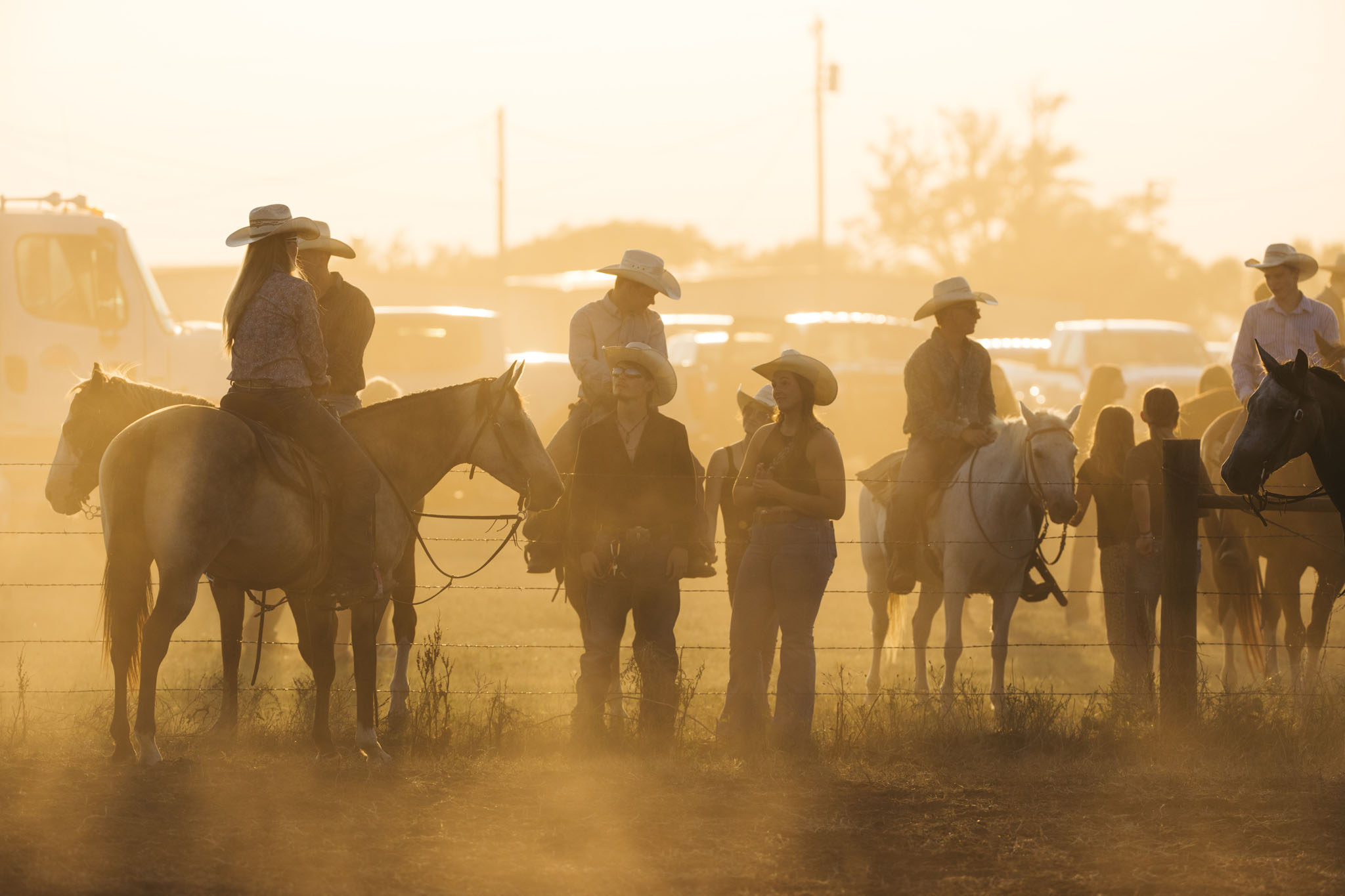 Riders gathered in the dusty arena at golden hour