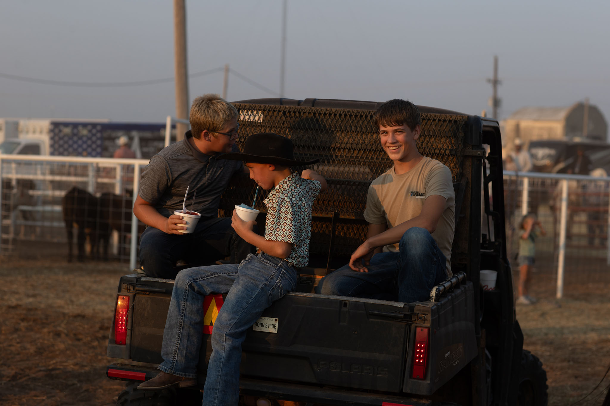 Friends sitting on a pickup tailgate watching the rodeo