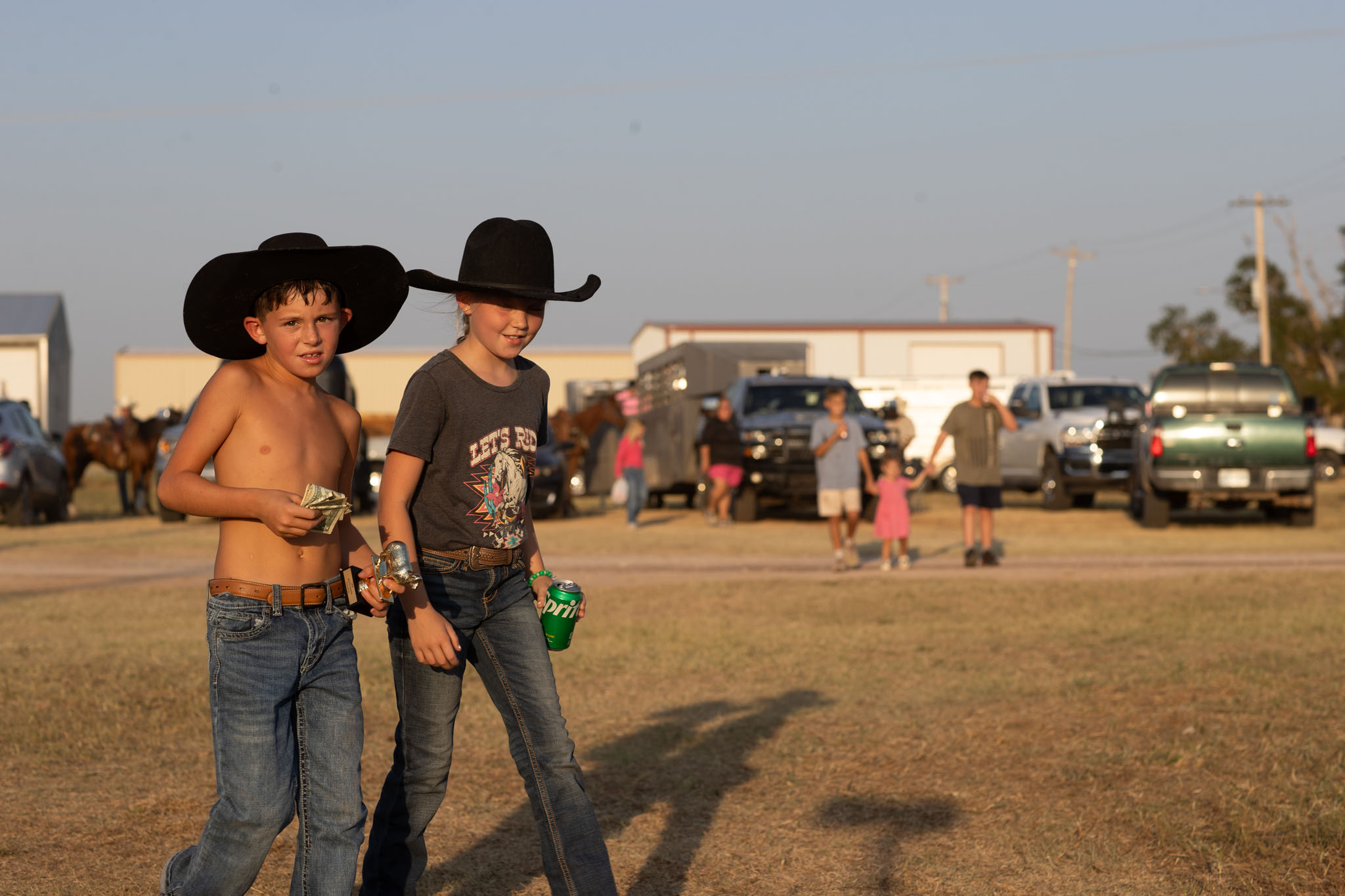 Two boys in black cowboy hats on the rodeo grounds