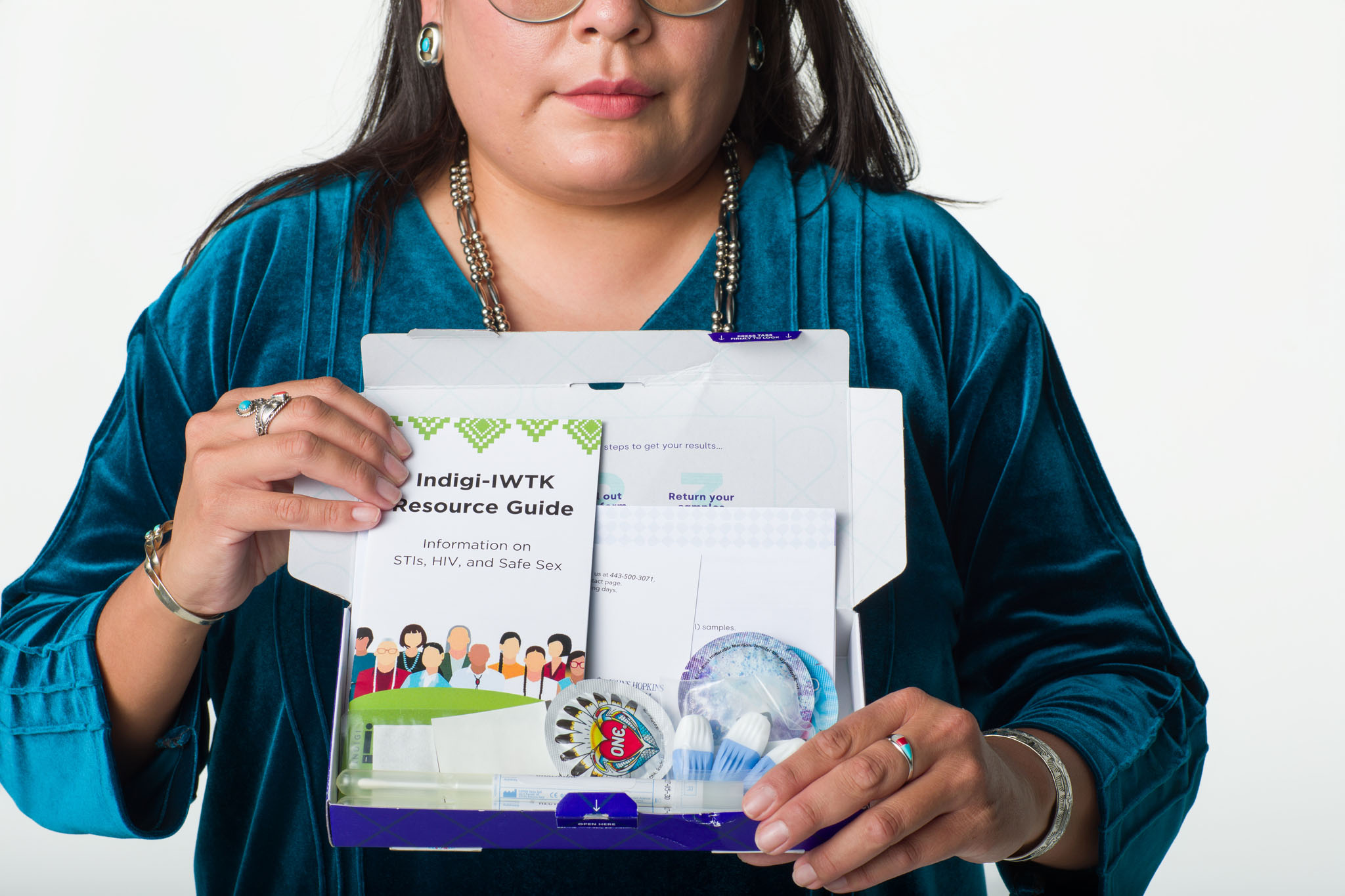 Woman holding an at-home STI and HIV test kit and resource guide