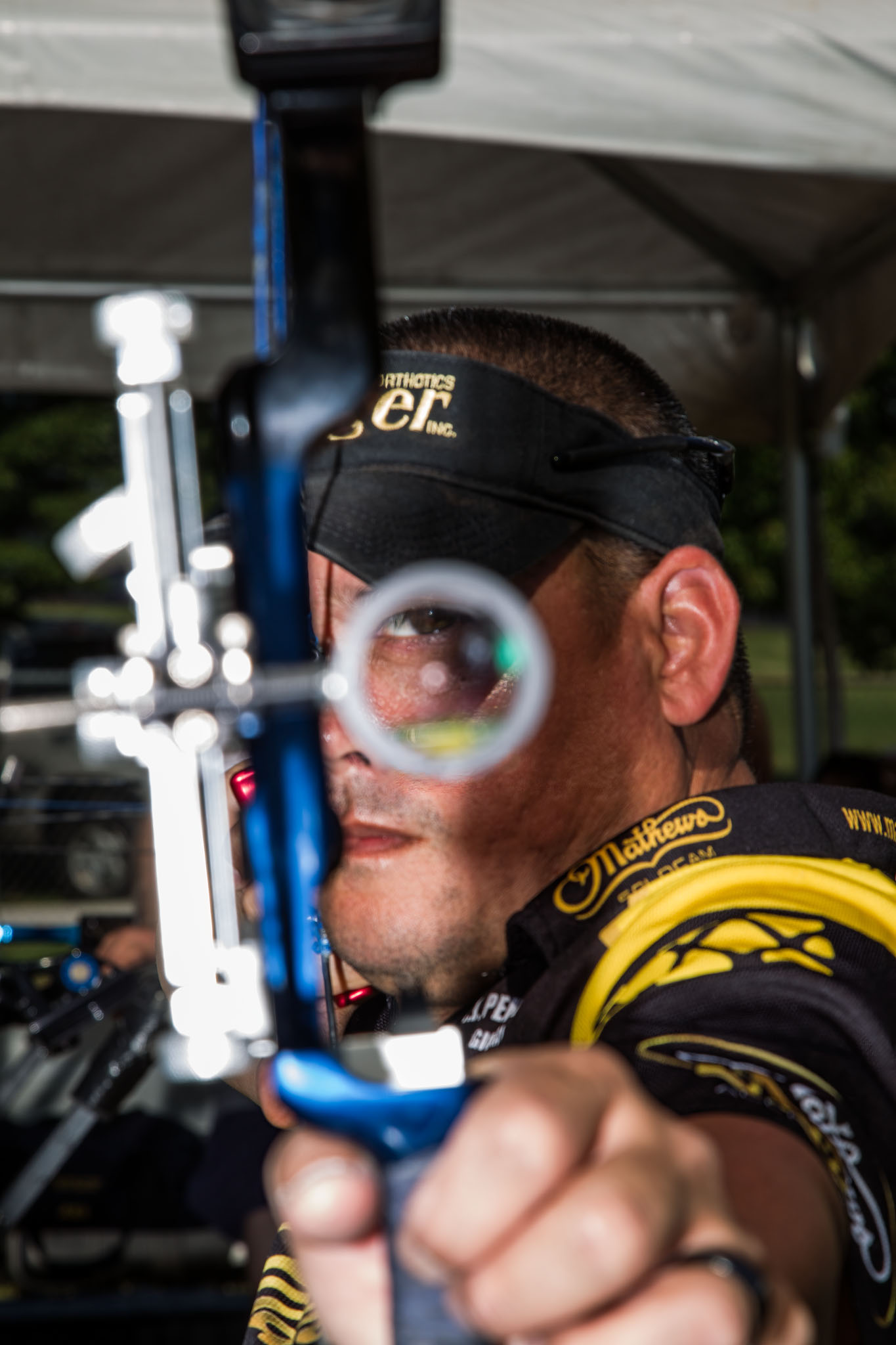 Archer drawing a compound bow aimed toward the camera