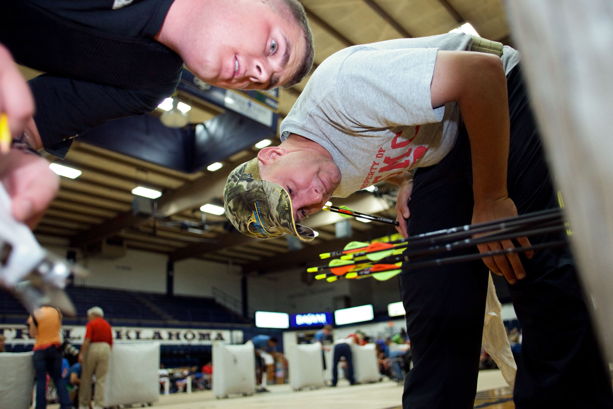 Archer sighting down an arrow in a gymnasium