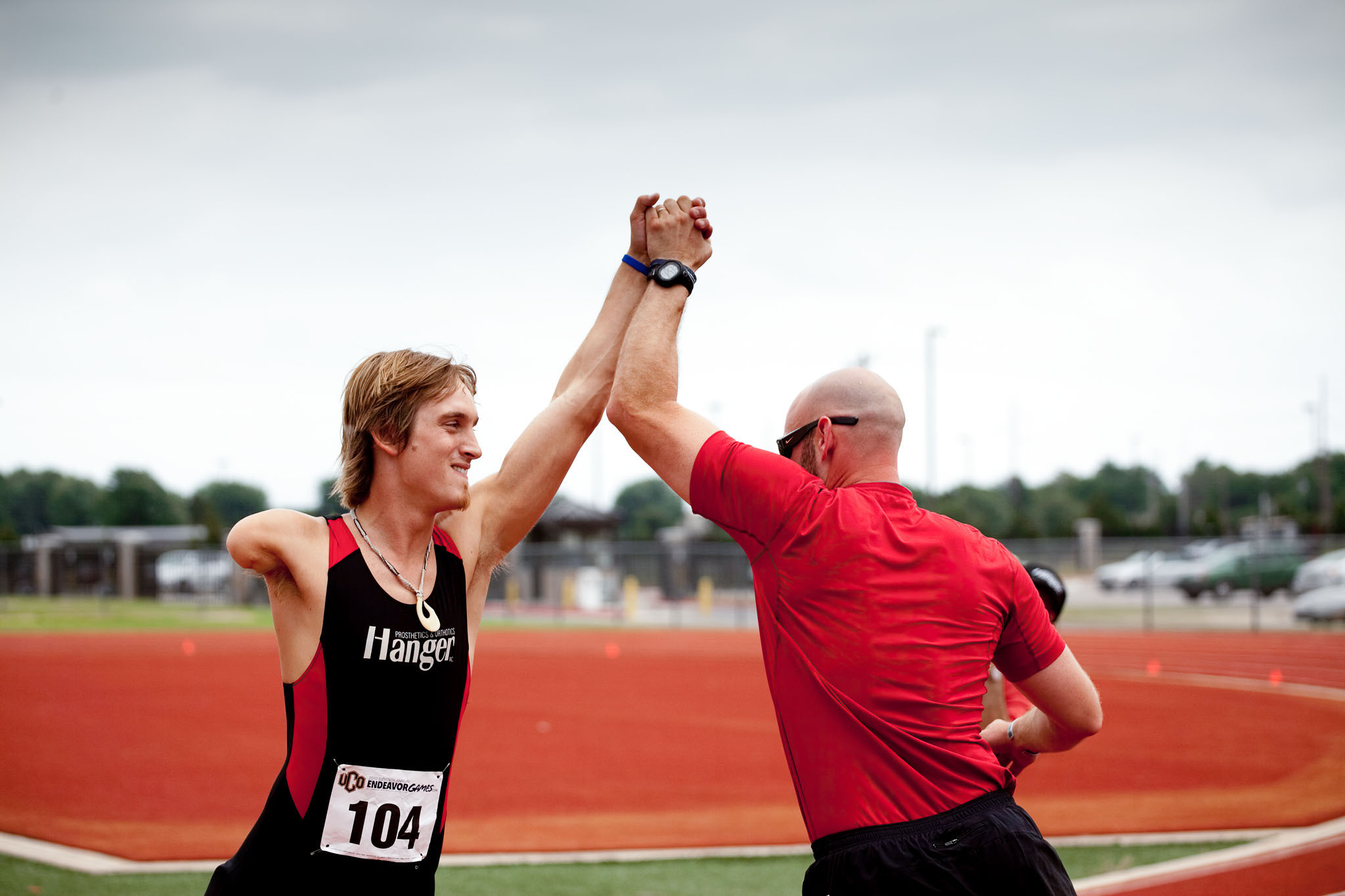 Athlete and coach sharing a high five on the track