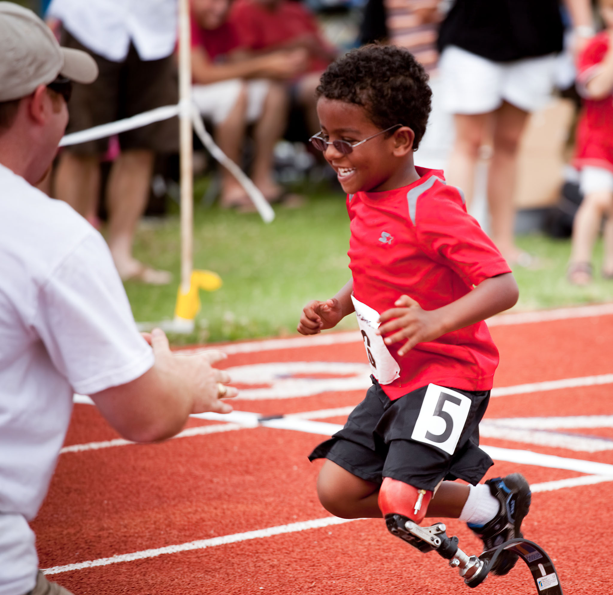 Boy on running blades racing toward a high five
