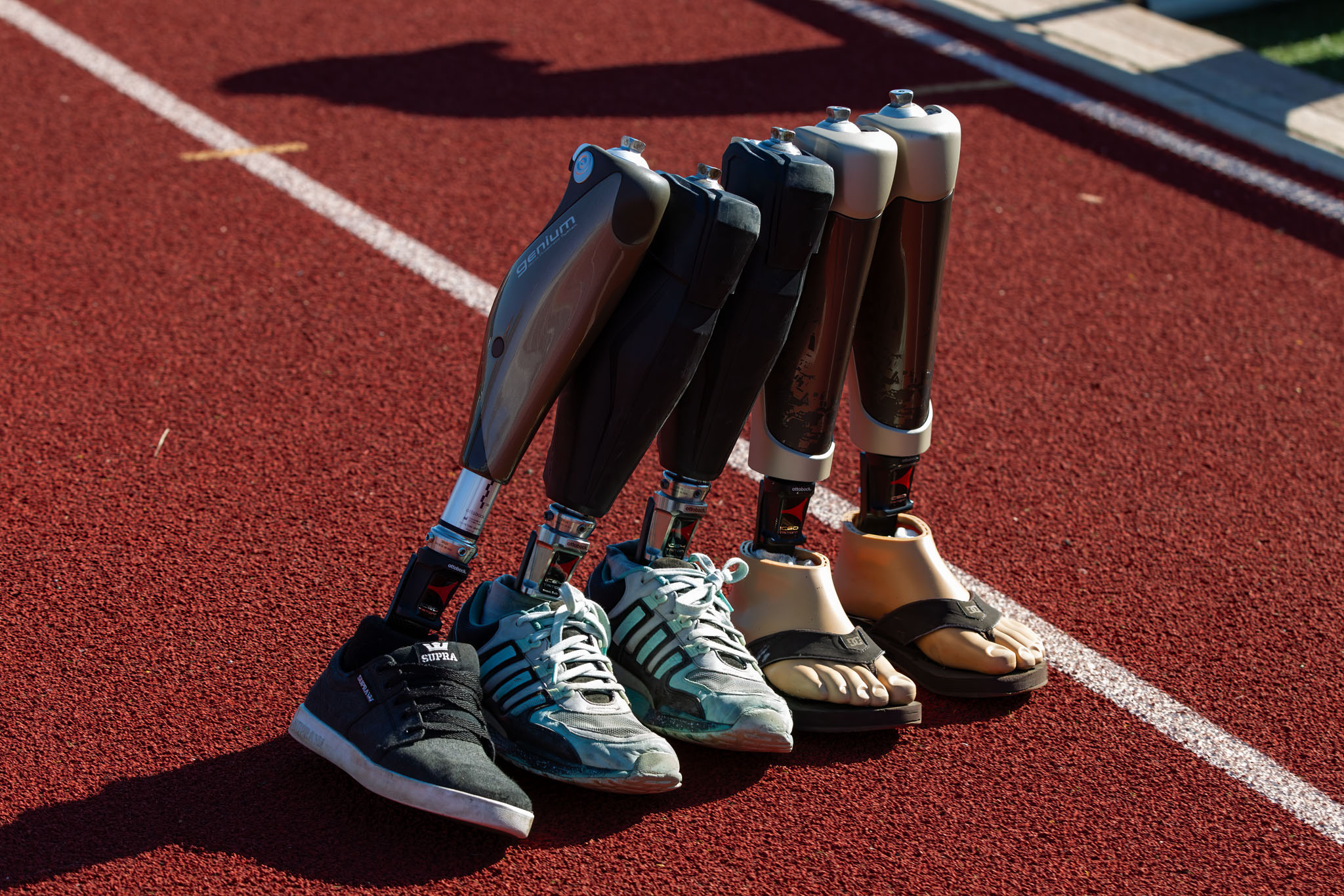 Row of prosthetic legs and running blades lined up on the track