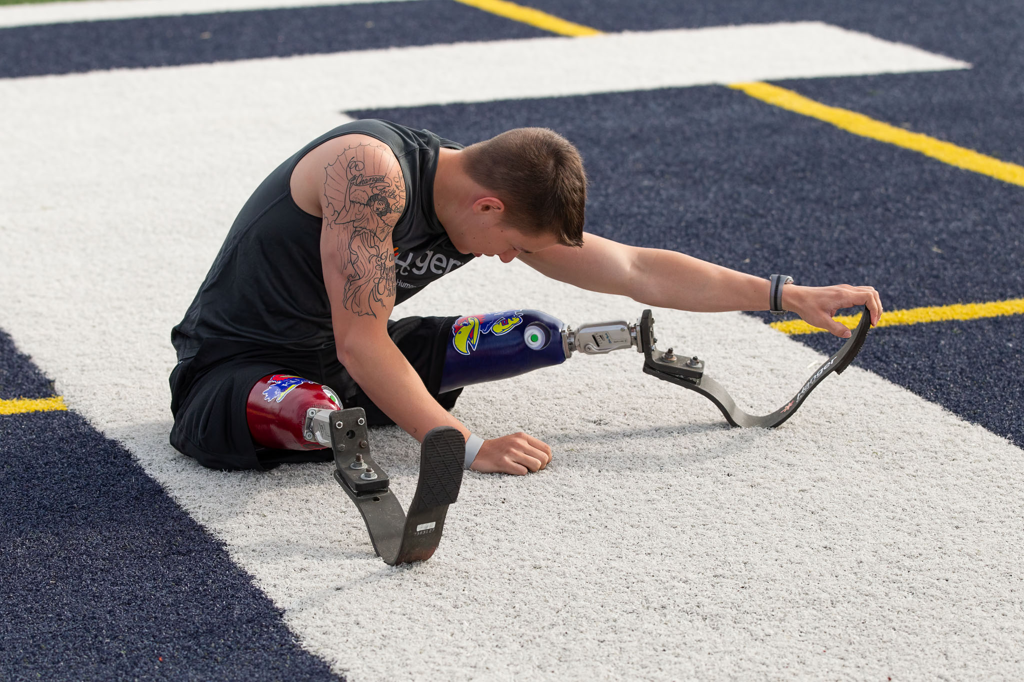 Athlete with a running blade stretching on the track before an event