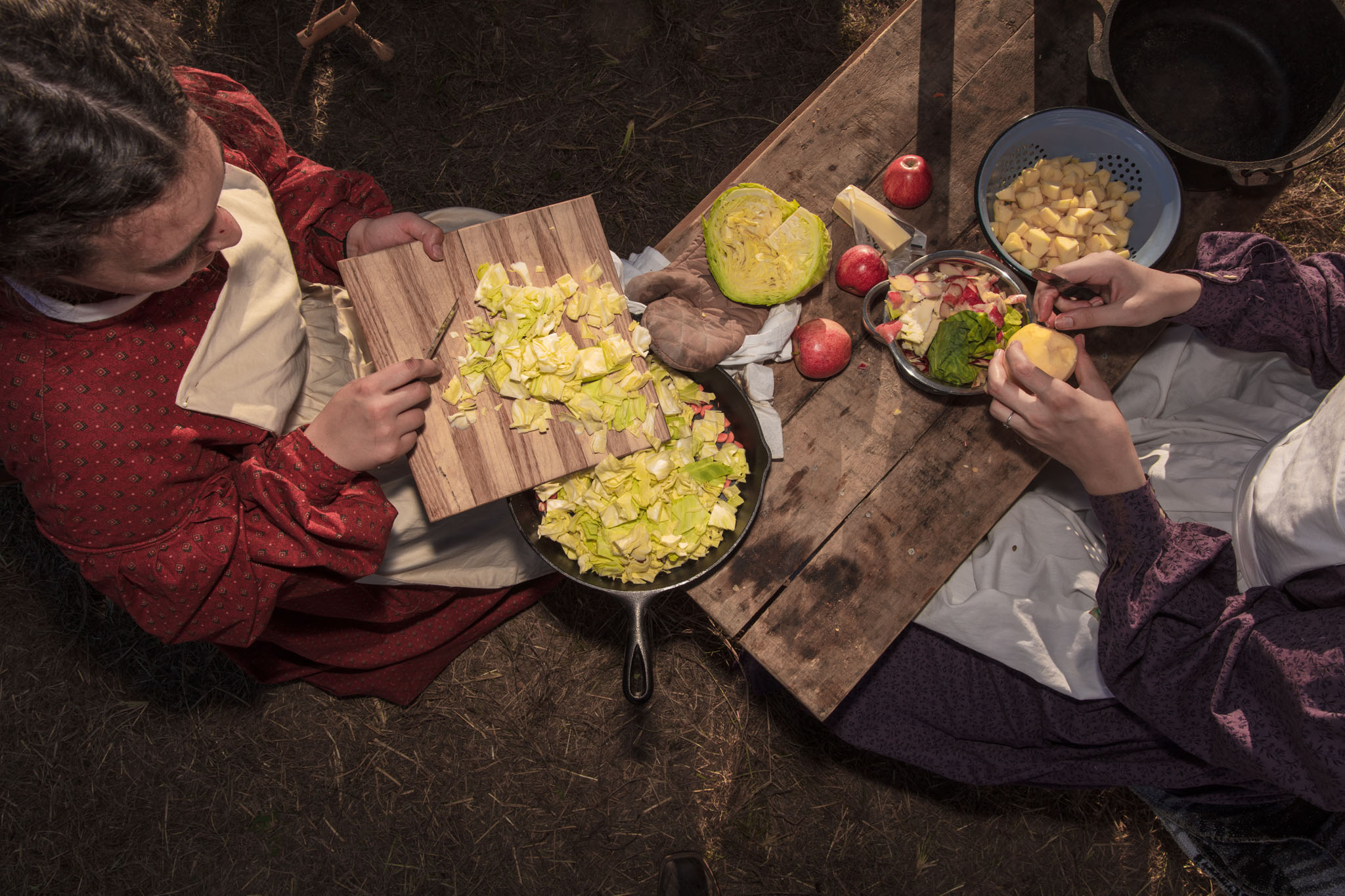 Overhead view of women preparing a meal on a wooden table