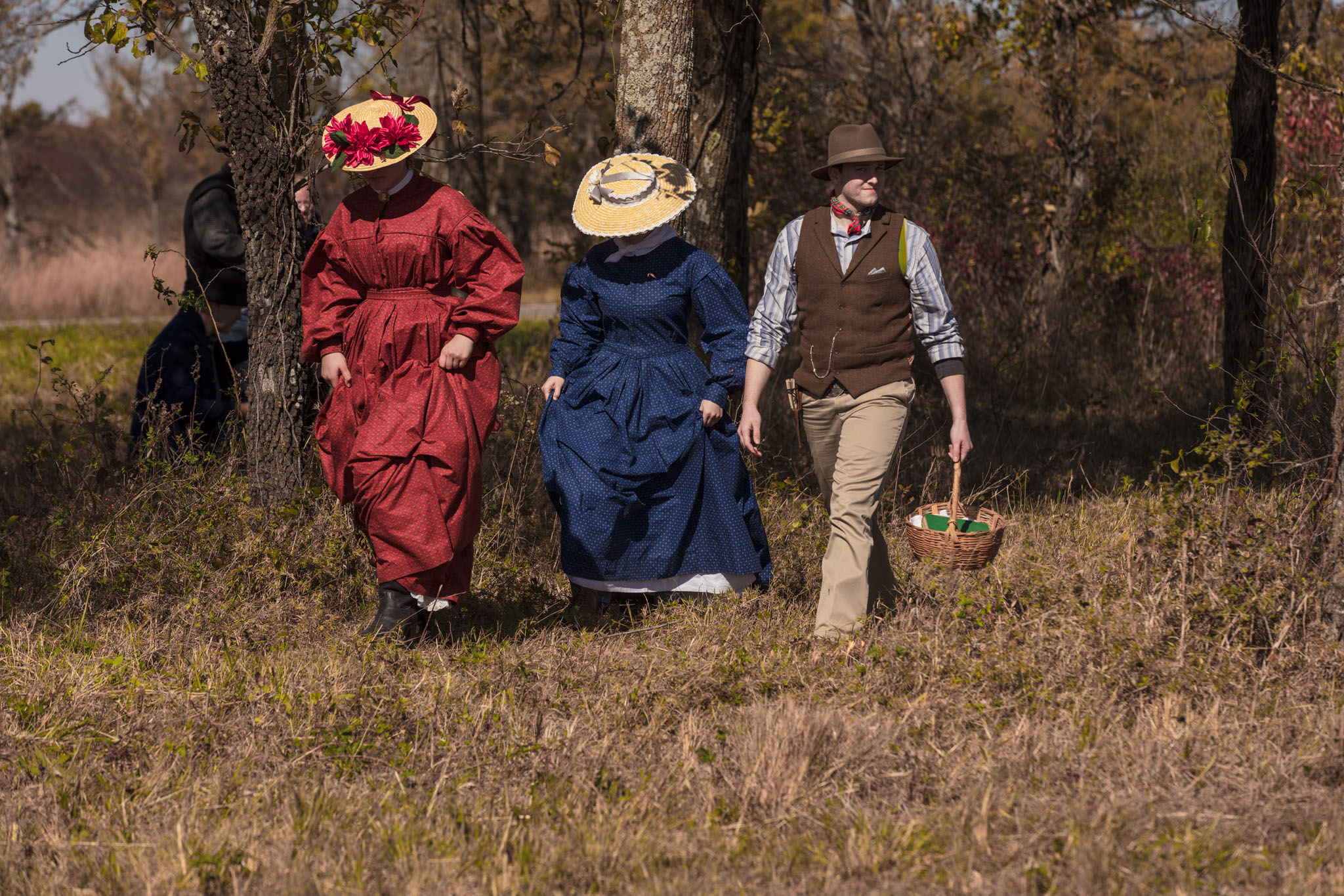 Reenactors in period dress walking out of the trees