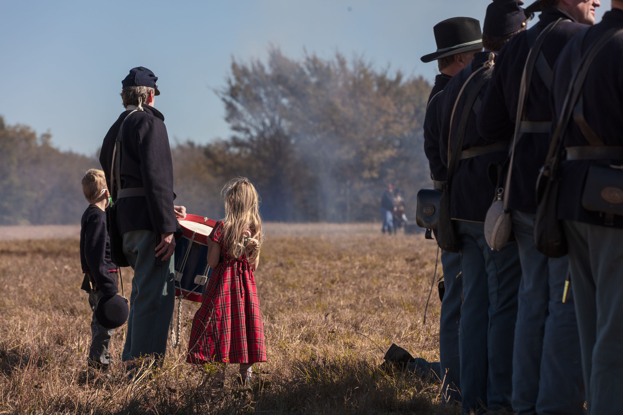 Union soldiers and a girl in a red dress watching the battle