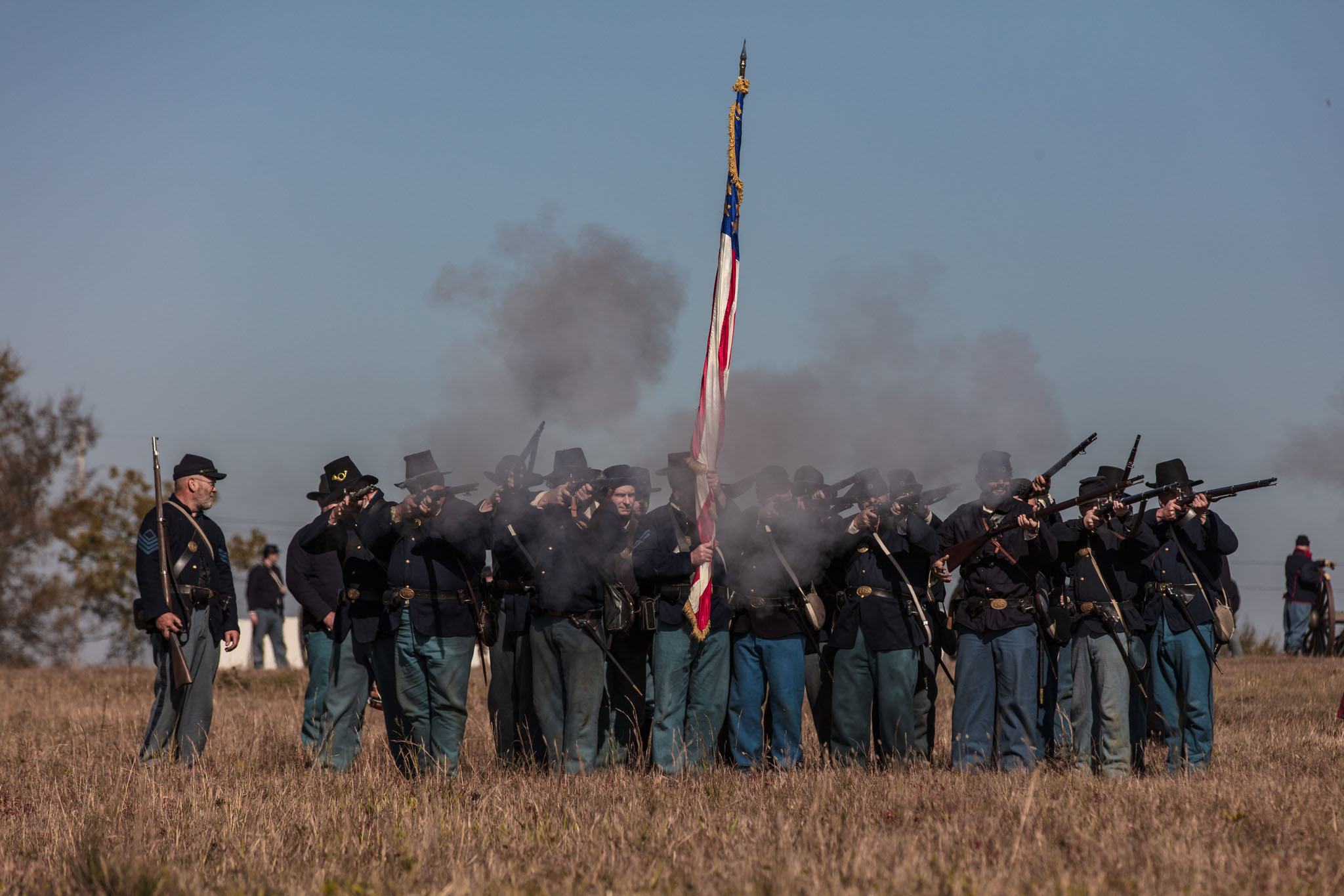 Union infantry line firing a volley beneath the flag