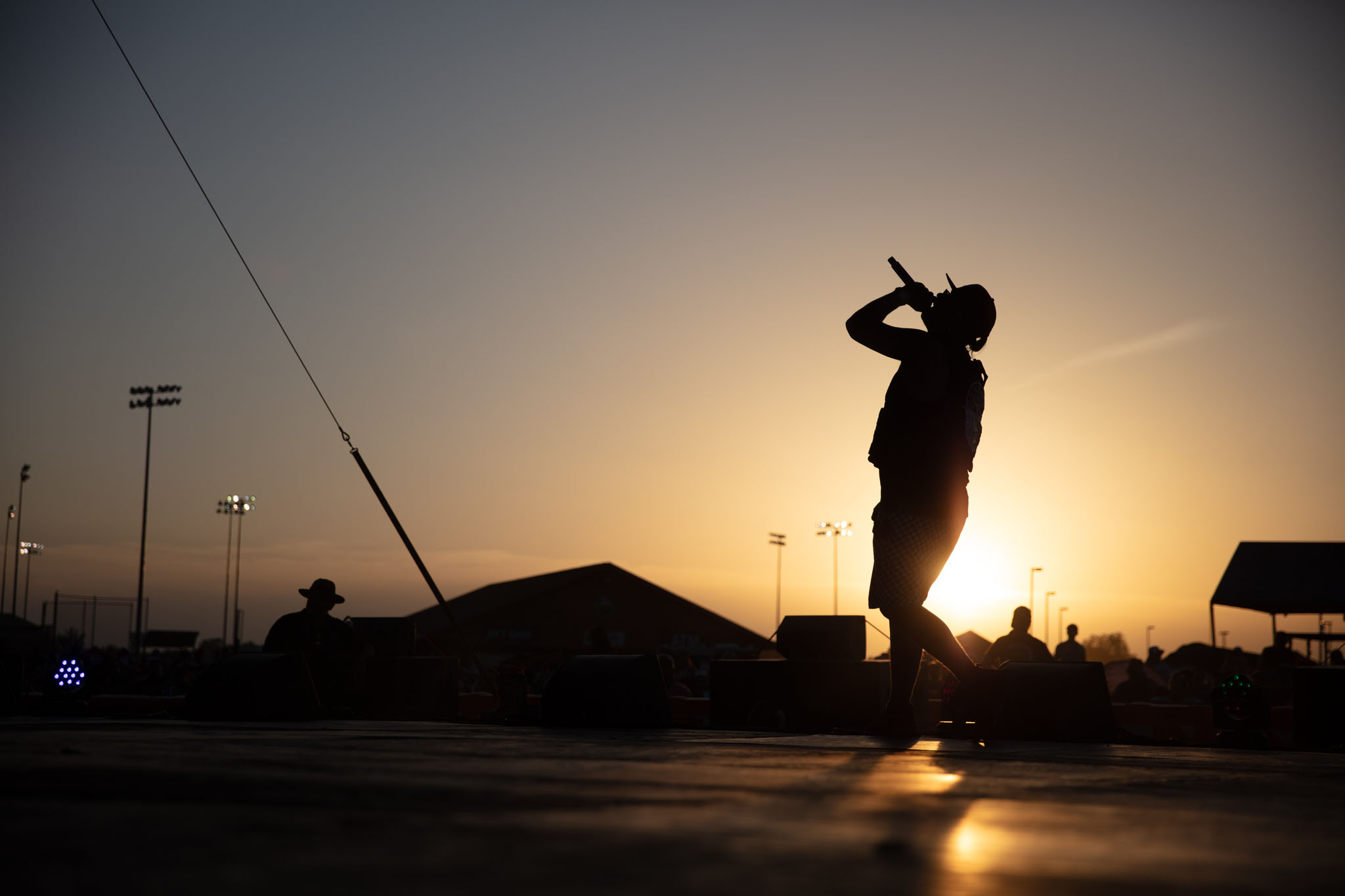 Man silhouetted at sunset on the festival grounds