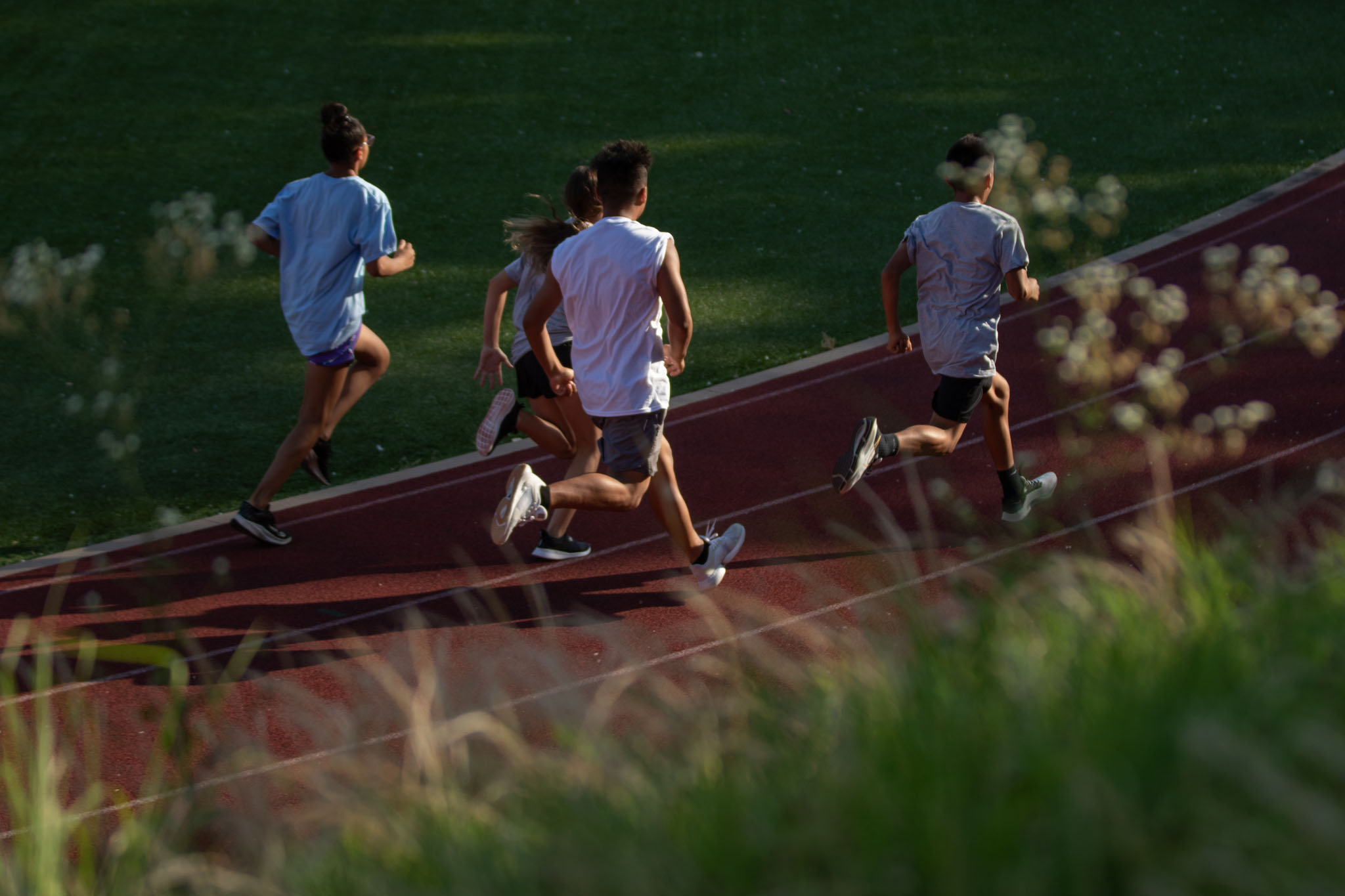 Children racing up a grassy hill beside the stadium