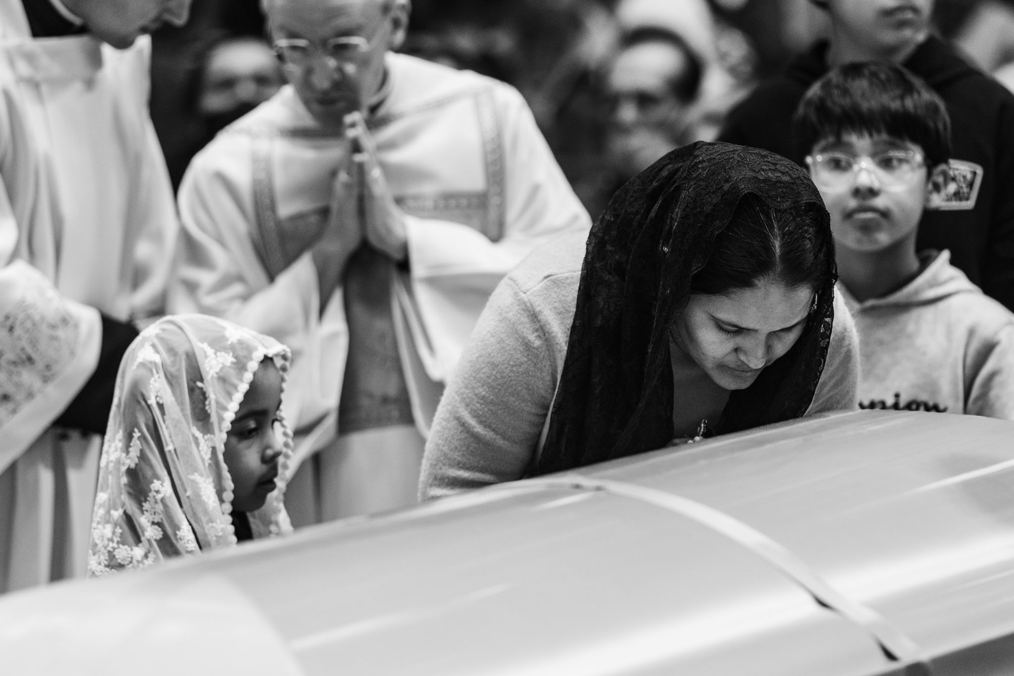 Worshippers praying beside Stanley Rother’s casket during the vigil