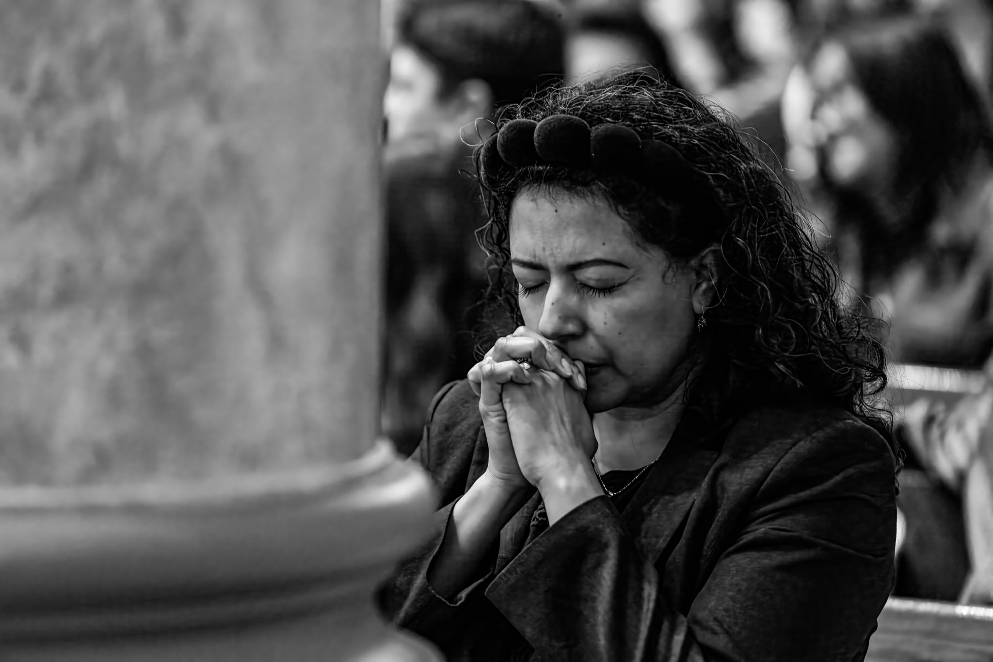 Woman praying with folded hands during the vigil