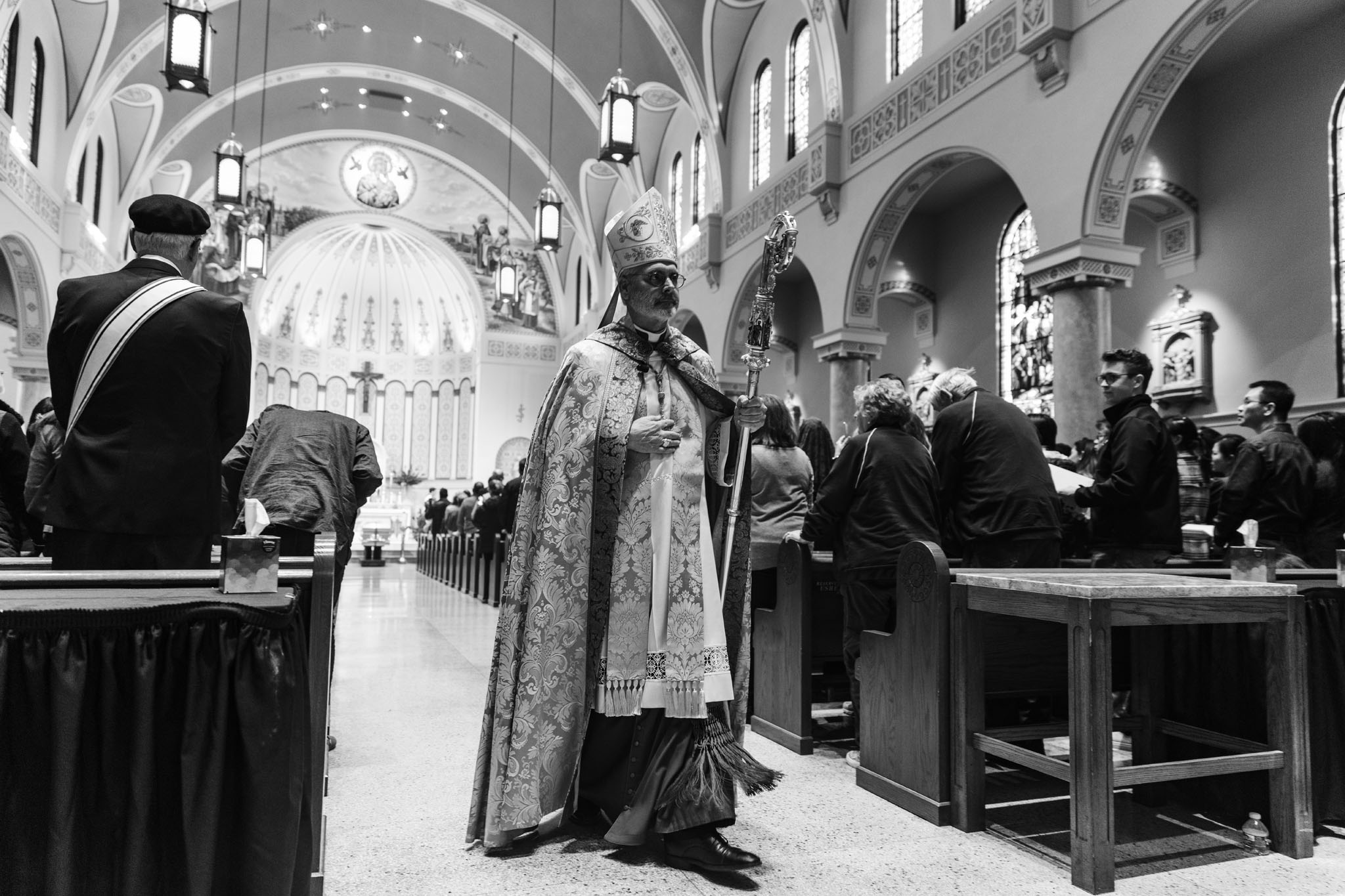 Priest kneeling in prayer in the aisle of the cathedral