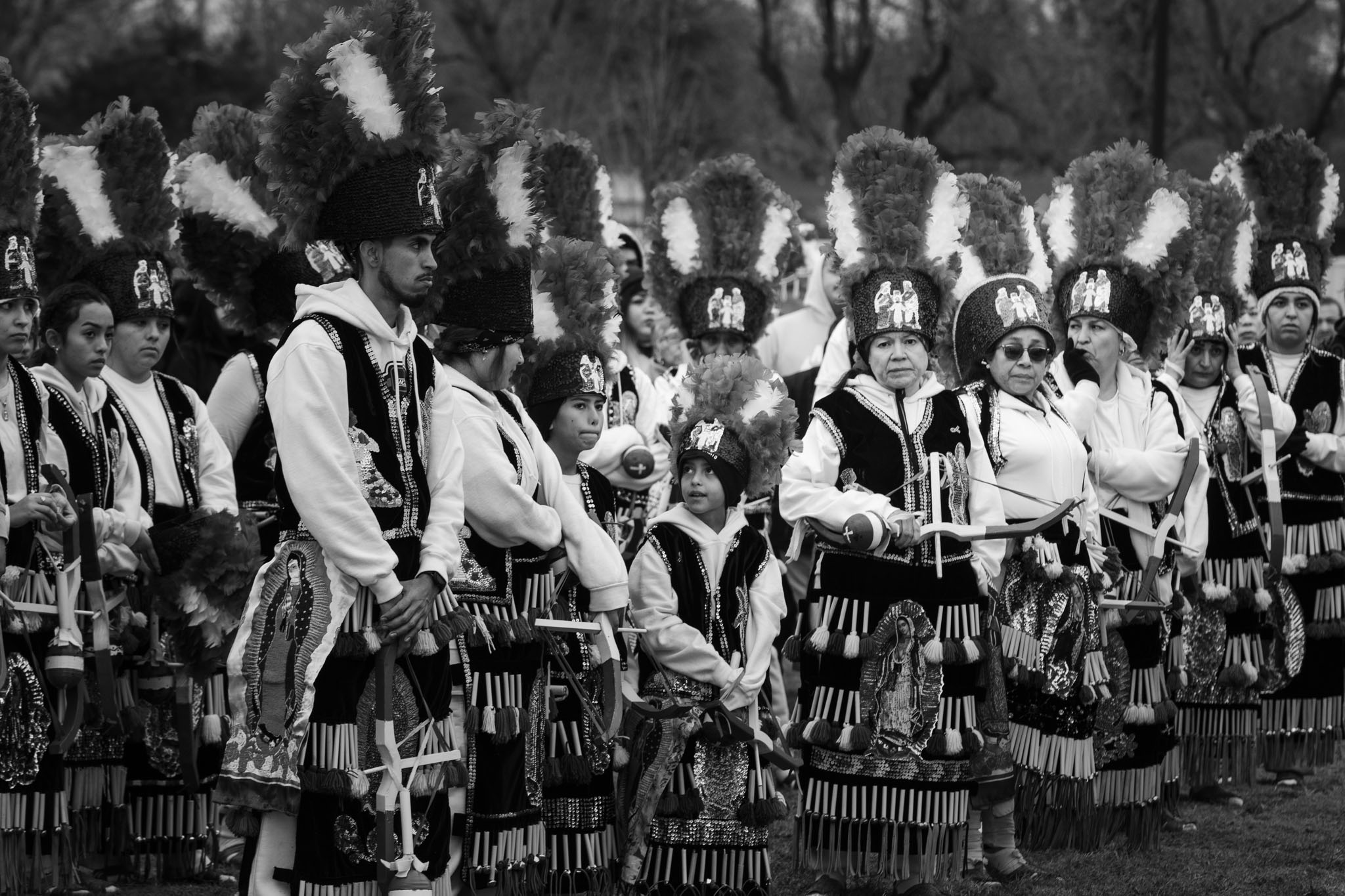 Rows of Matachines dancers in feathered headdresses performing at the shrine
