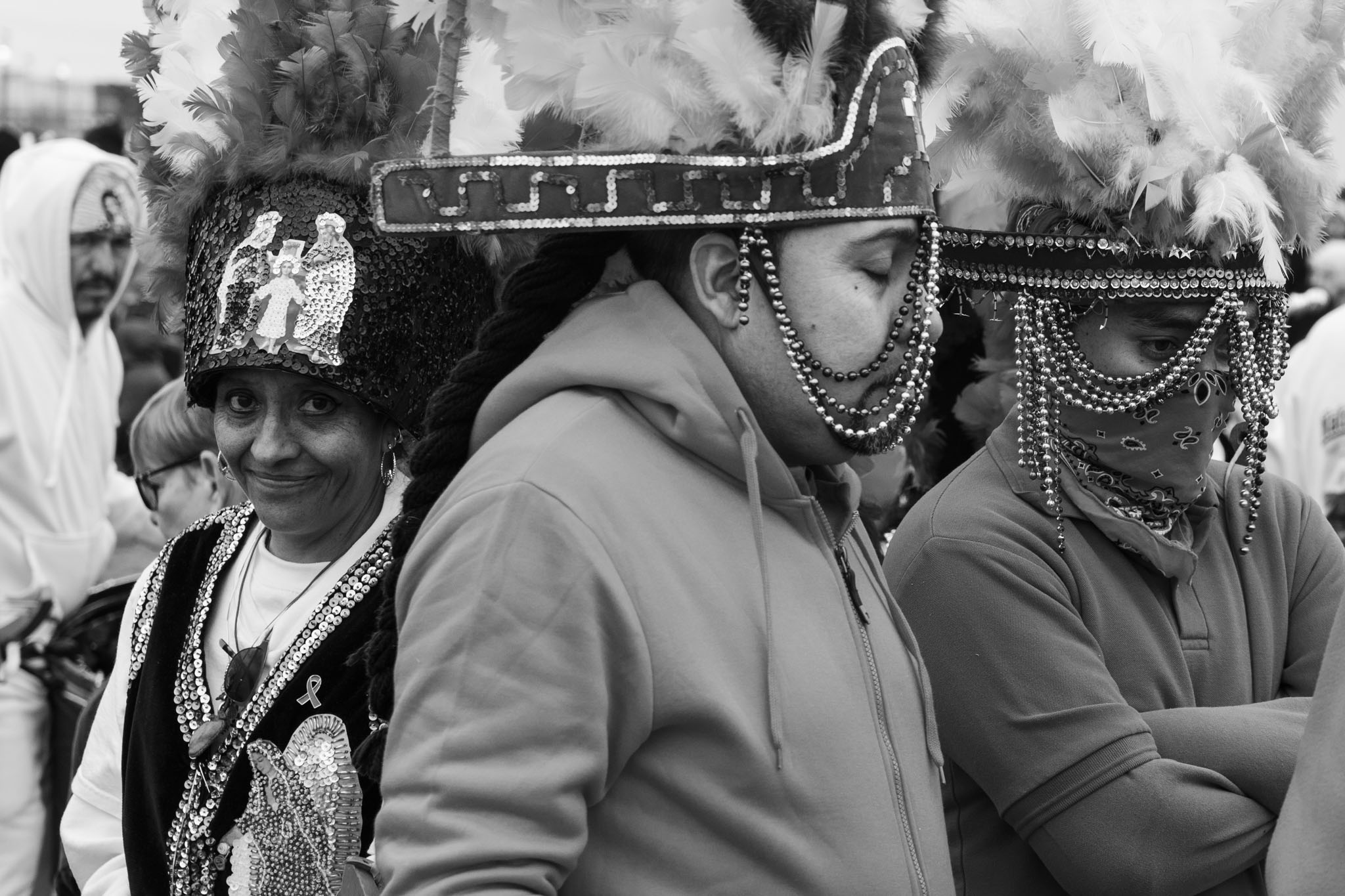 Matachines dancers in feathered headdresses and beaded veils waiting to dance