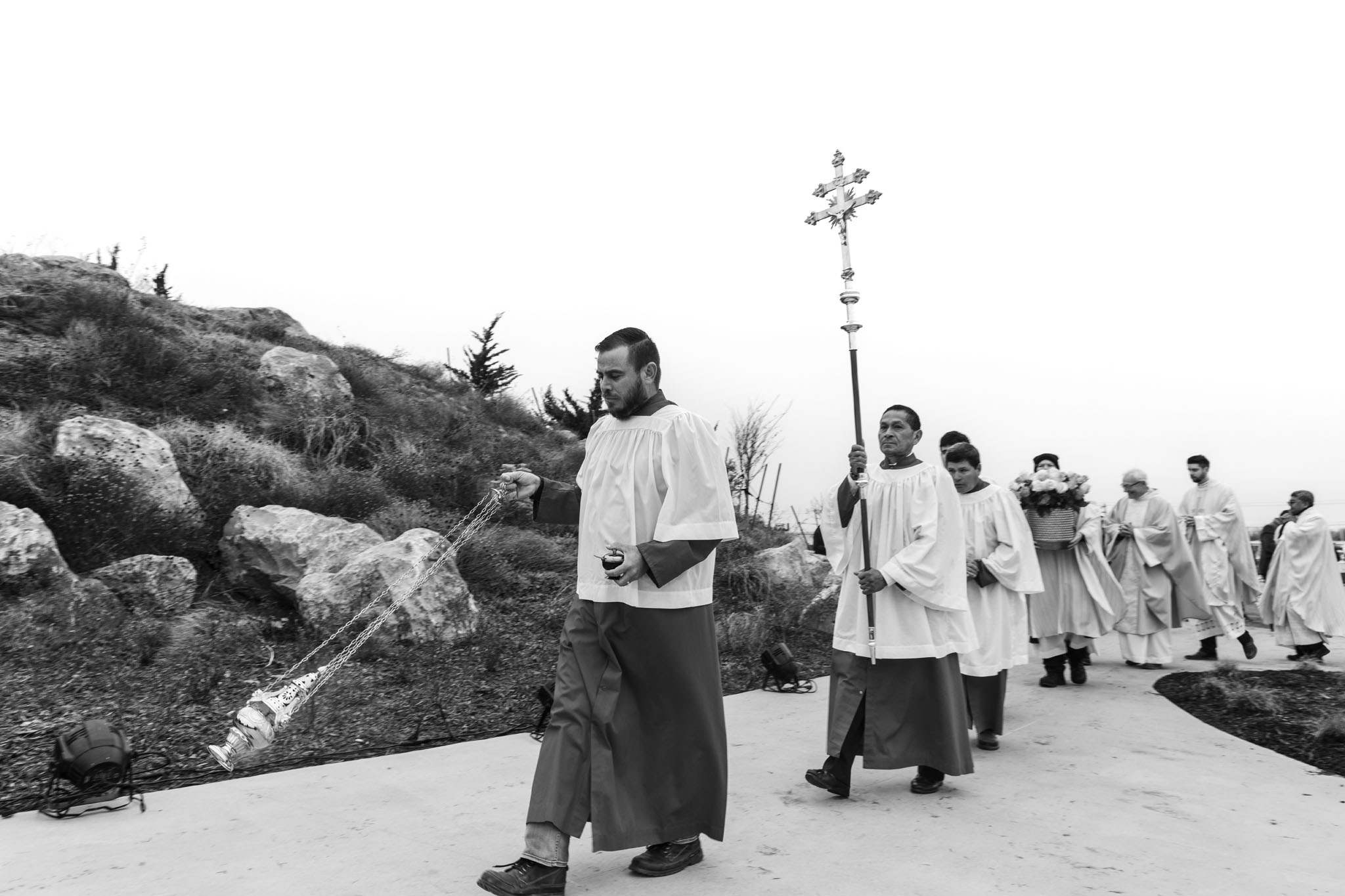 Altar servers carrying a processional cross and censer lead clergy in procession at the Blessed Stanley Rother Shrine