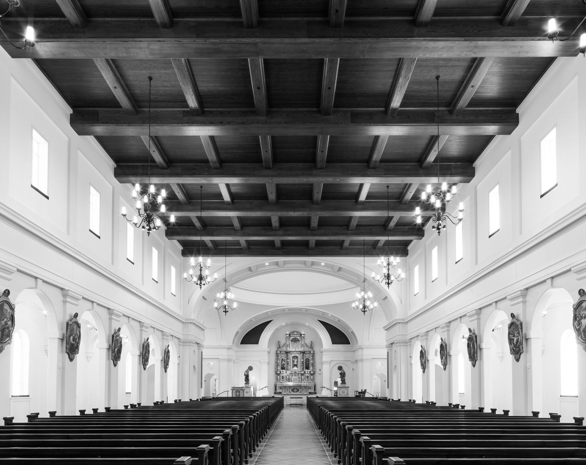 Interior of the new shrine church with rows of wooden pews and a beamed ceiling