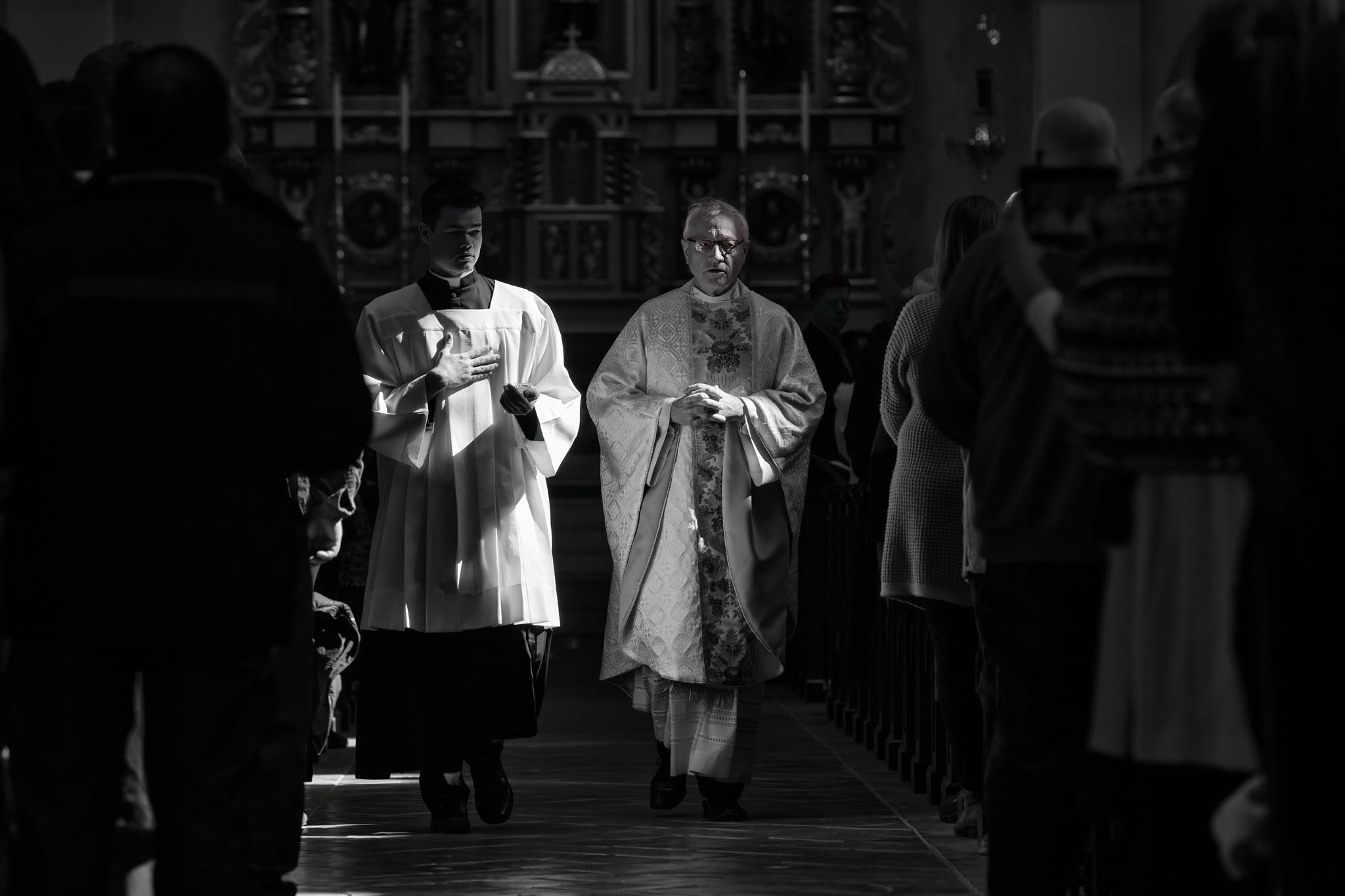 Clergy processing down the aisle in the dim church